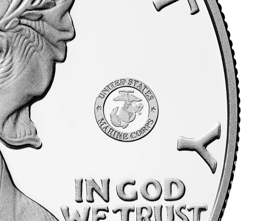 Close up of American eagle silver dollar featuring the US Marine Corps 250th anniversary privy mark consisting of a circular emblem that reads 'UNITED STATES MARINE CORPS' surrounding the Marine Corps insignia.